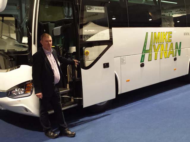 Mike Hynan standing infront of his 53 seater coach